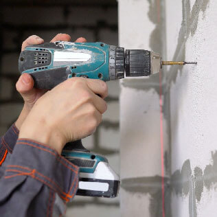 Pre-drilling cinder block for an anchor